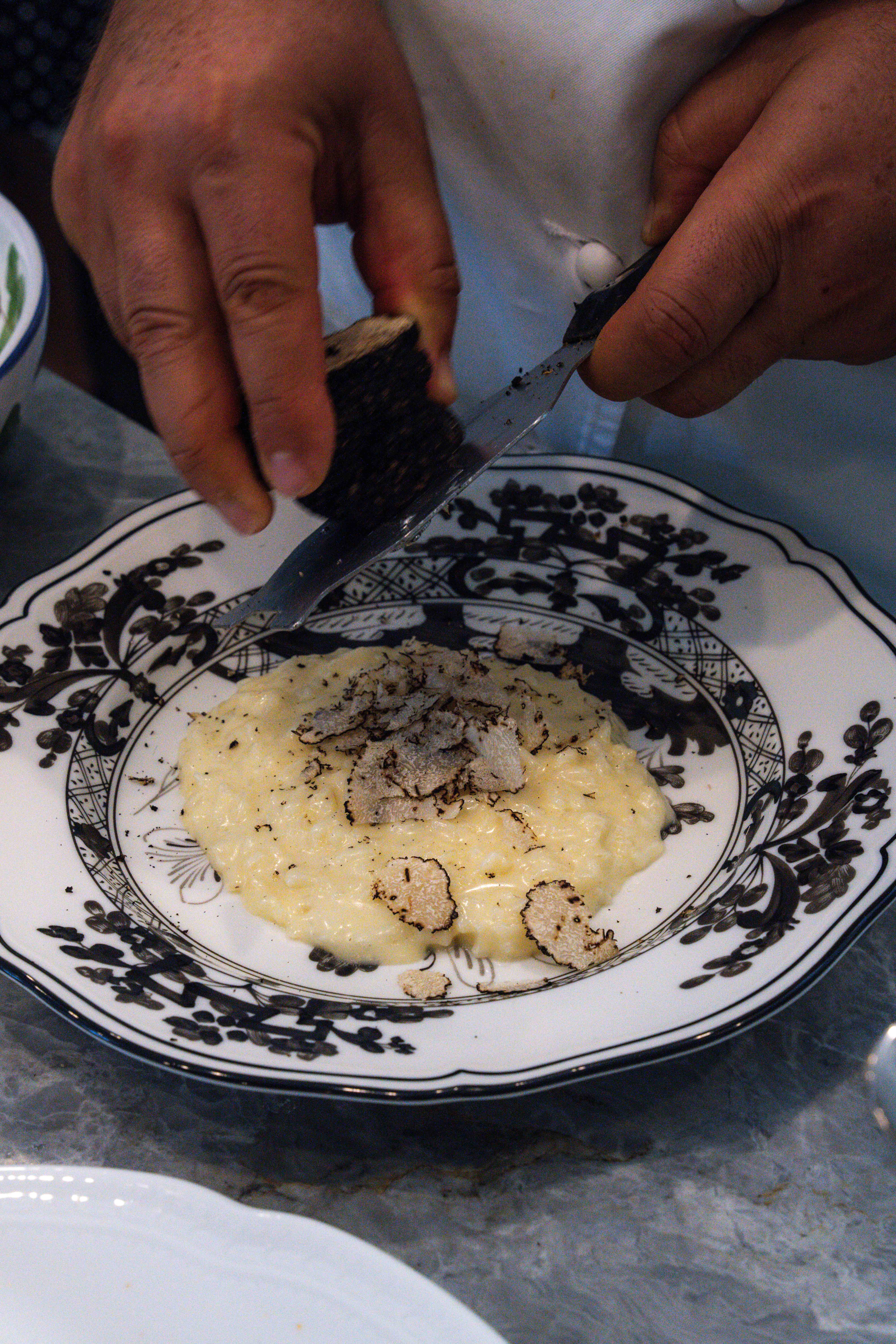 Chef Giacomino generously shaves truffles on a pasta plate Chef Giacomino Drago in the kitchen
