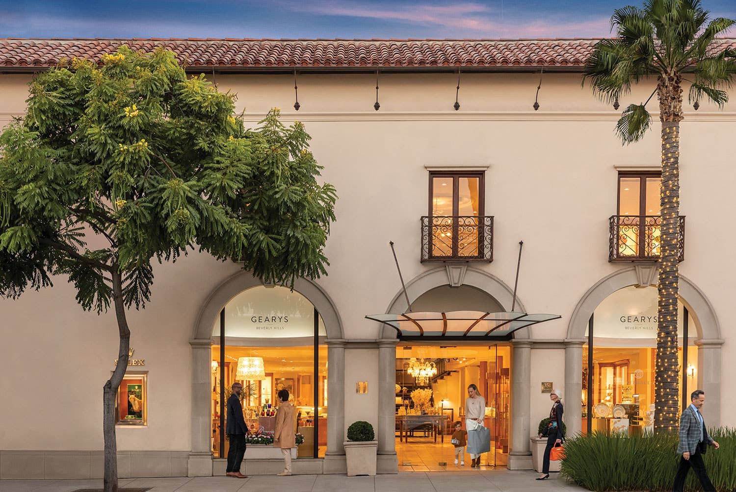 GEARYS Beverly Hills storefront located at 351 Beverly Drive, pictured at sunset with people window-shopping, exiting the front doors with gifts, and passing by on the sidewalk.