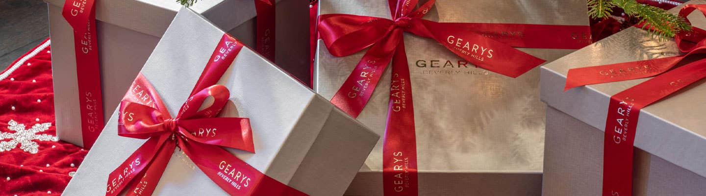 GEARYS Gift Boxes with red ribbons underneath the Christmas tree GEARYS Gift Boxes with red ribbons underneath the Christmas tree
